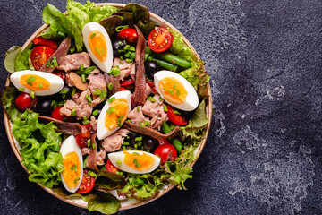 salad Nicoise with tuna, eggs, green beans, tomatoes,  olives, lettuce and anchovies