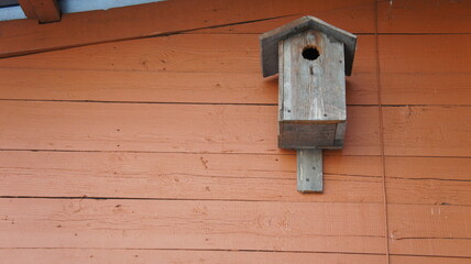 Old birdhouse on the background of a painted board