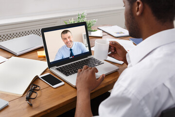Obraz premium Businessman At Laptop Having Online Meeting With Coworker At Workplace