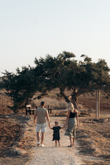 Family men women little girl walking to the tree of love in Cyprus