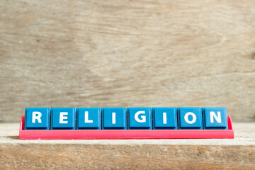 Tile letter on red rack in word religion on wood background