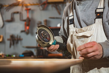 Male carpenter working on old wood in a retro vintage workshop.