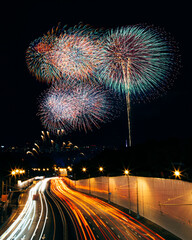 Fireworks over the city highway with light trails from cars 
