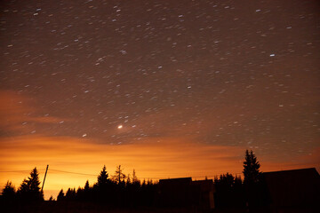 Milky Way stars and suburb countryside silhouettes.
