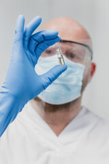 Masked scientist holding vial