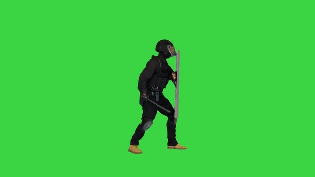 Special unit policeman running into the frame, holding shield up and hitting it with the baton for intimidation on a Green Screen, Chroma Key.