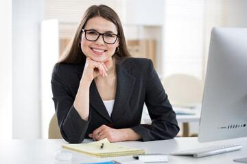 Portrait of business woman looking at camera at workplace in an office