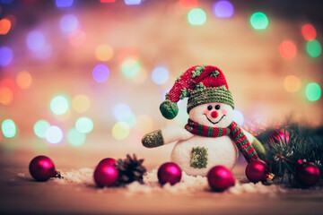 cheerful snowman in knit hat and Christmas decorations on festiv