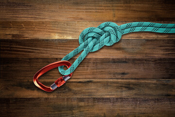 Carabiner with Rope abseling on wooden background, Hiking and mountaineering equipment concept.