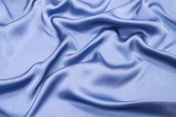 Blue silk or satin luxury fabric texture. Top view.