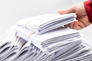 paperwork deadline concept. side view for a minimal workspace with big heap files. work organization conceptual. studio shot. copy space