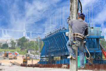 Workers climb electric poles, repair old cables with seat belts in construction site.
