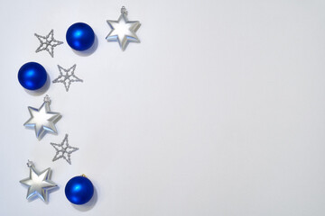 blue balls and silver stars on the white background. Greeting card, banner, frame. New Year. Merry Christmas decoration.