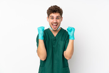 Surgeon in green uniform isolated on isolated white background celebrating a victory in winner position