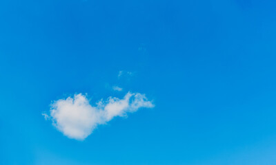 Small, fluffy and lonely clouds in the blue sky for texture background with copy space