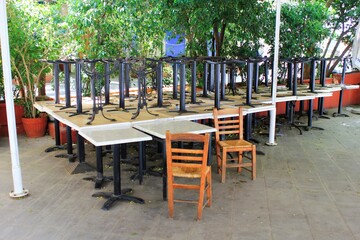 Tables and chairs stacked outside closed cafe-restaurant due the Coronavirus lockdown - Athens, Greece, May 6 2020.