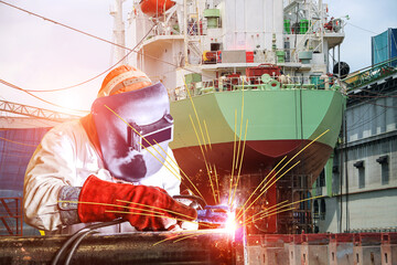 Worker is Welding with sparks light for ship repair in shipyard.