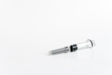 A syringe with a needle and a cap for medical vaccination on a light background lies on the table. copy space.