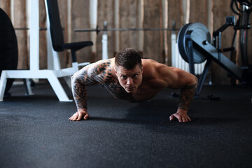 dedicated bodybuilder performing push-UPS in the gym.