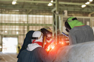 Team Welder Welding big steel pipe with spark light in factory