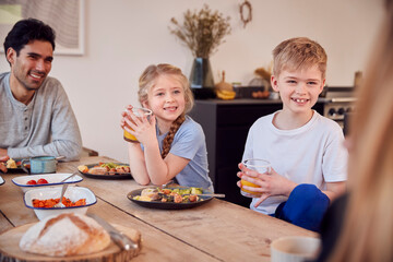 Obraz na płótnie Canvas Family Sitting Around Table At Home In Pyjamas Enjoying Brunch Together