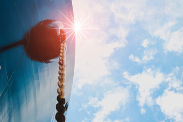 Front View ship with anchor center forecastle deck of commercial ship floating in port against sun light sky