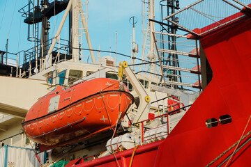 Davit lifeboat, Rescue boat or lifeboat of tugboat moored alongside under repair in shipyard and...