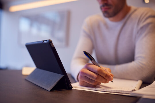 Close Up Of Man In Kitchen Working Or Studying From Home Using Digital Tablet