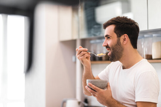 Young Smiling Man Eating Cereal On Diet Isolated On White Background.