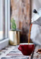 Steaming coffee over wooden surface and black background