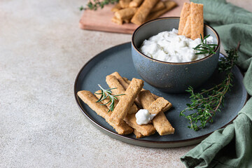Blue cheese dressing or dip sauce with rosemary and gingerbread cookies sticks on concrete...