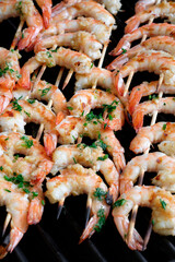 Grilled king prawns on wooden skewers.