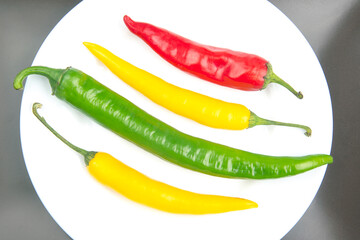 Fototapeta na wymiar yellow, red and green hot chili on a plate. Pepper. Vegetable vitamin food.