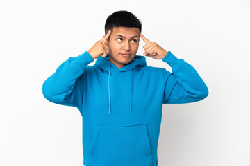 Naklejka premium Young Ecuadorian man isolated on white background having doubts and thinking