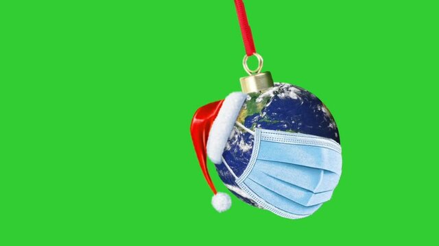 Christmas during pendemic ,chrismas ornaments decor , earth planet wearing Covid 19 masks in Christmas Stay safe at home concept. Green screen Close up 4K