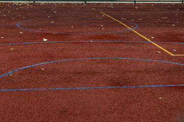 Yellow and blue lines on the dark red sports ground as a background.Empty space