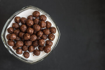 Children food. Delicious light breakfast. Crispy chocolate balls. Flakes with yogurt. Healthy food. A nutritious snack. Food photo. Sweet milk dessert. Morning diet. Cereals, cocoa and milk.