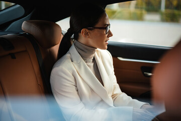 Positive optimistic business woman sitting in a car