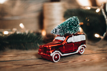 Vintage retro car with christmas tree on the roof. Scandinavian hygge styled Christmas composition. Fir tree, vintage Christmas tree toys. Winter cozy vintage flat lay. New Year holidays.  - Powered by Adobe