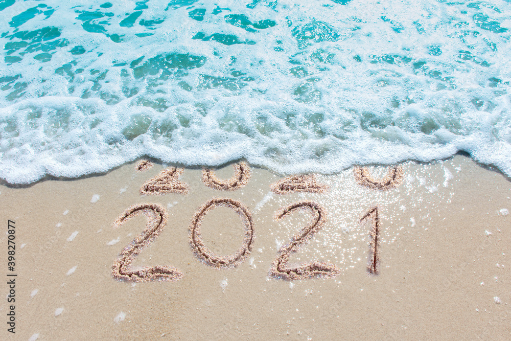 Wall mural message year 2020 replaced by 2021 written on beach sand background. good bye 2020 hello to 2021 hap