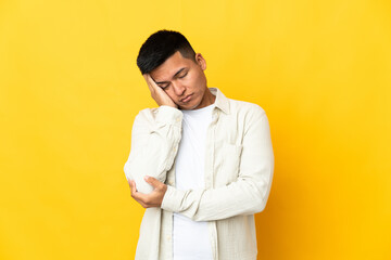 Young Ecuadorian man isolated on yellow background with headache