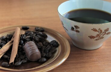 cup of coffee with beans and chocolate candy