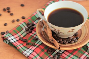 cup of coffee with cinnamon, beans and chocolate