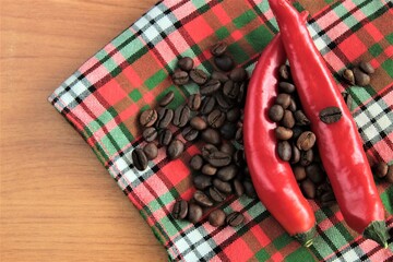 bitter coffee beans and peppers on wooden background