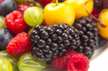 Assorted fresh different berries on a white plate. useful vitamin healthy food fruit. healthy vegetable breakfast