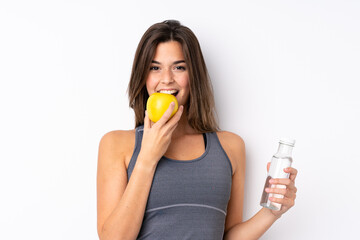 Teenager Brazilian girl with an apple and a with a bottle of water over isolated background