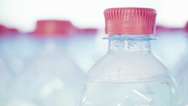 Drinking Water in Plastic Bottles. Close-up. Red Caps on Clean Water Bottles. Pure Drinking Water is Sold in Supermarkets and Shops. Selective Focus