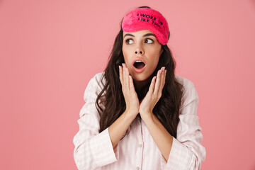 Shocked beautiful woman posing in sleeping mask and pajama