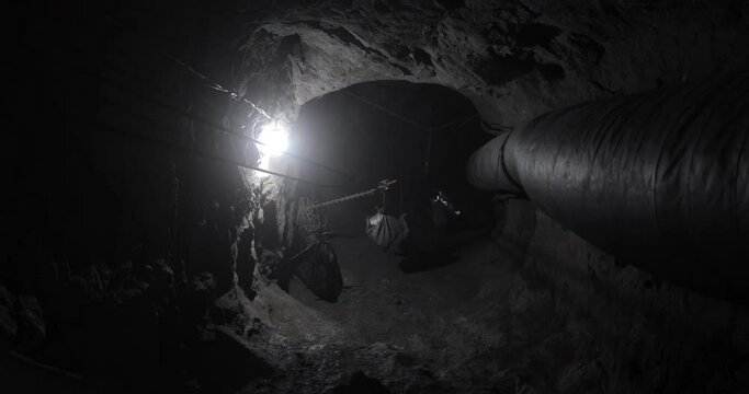 
The tunnel of the tanzanite mine which is hollowed out deep underground. Bags with a stone rise to the top and people work.