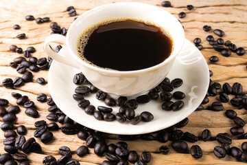 Coffee cup and coffee beans on texture old wood .